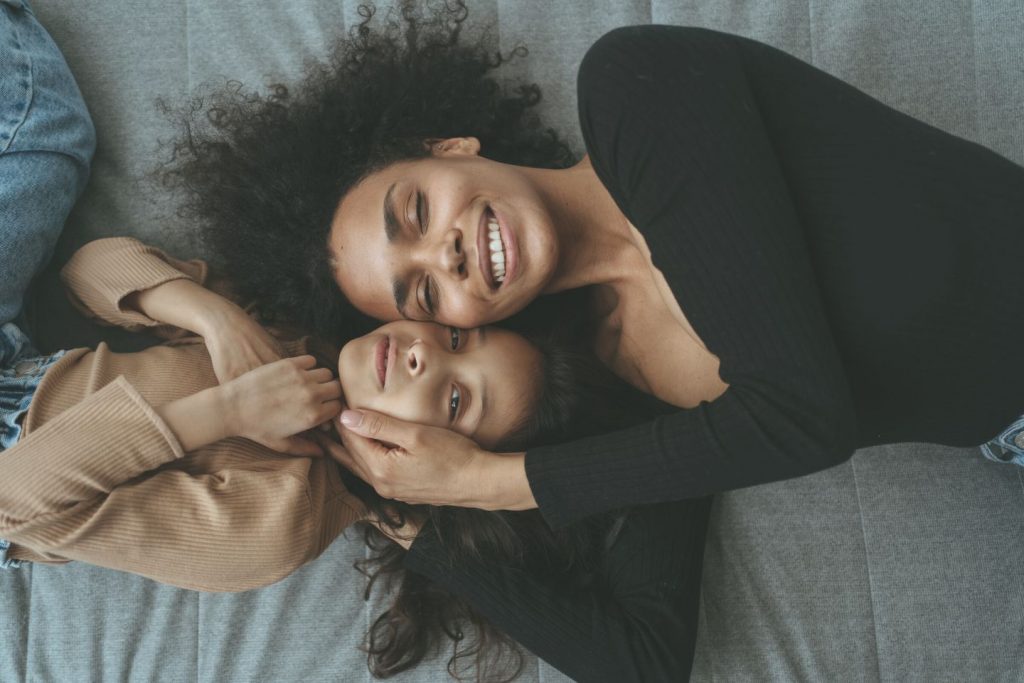 mom and daughter cuddles while lying down