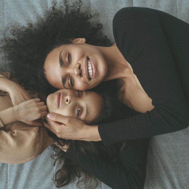 mom and daughter cuddles while lying down