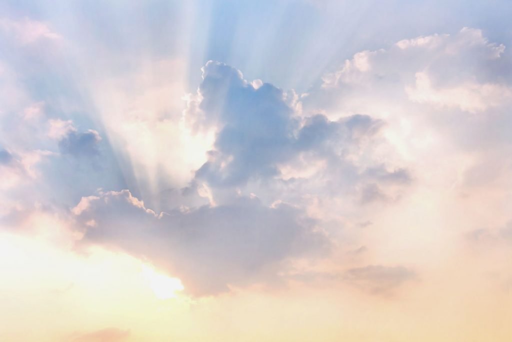 clouds and sun shines through rays of light in the illuminated picturesque sky