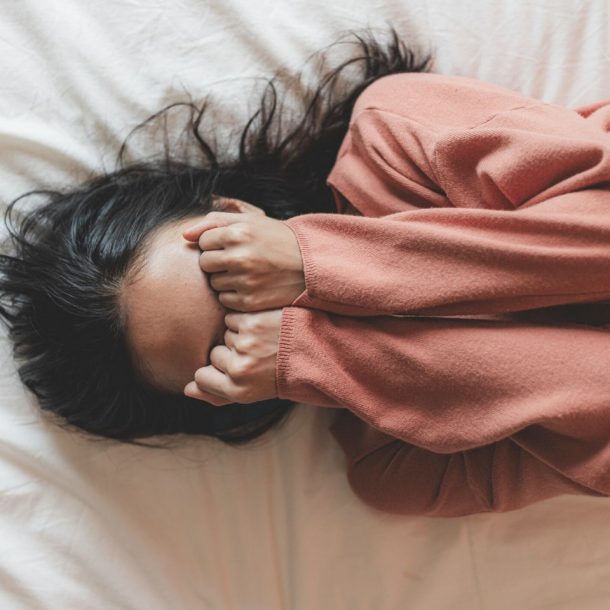 top view of a woman crying on the bed