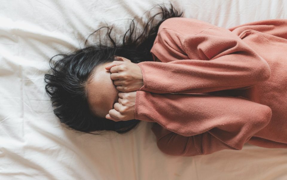 top view of a woman crying on the bed