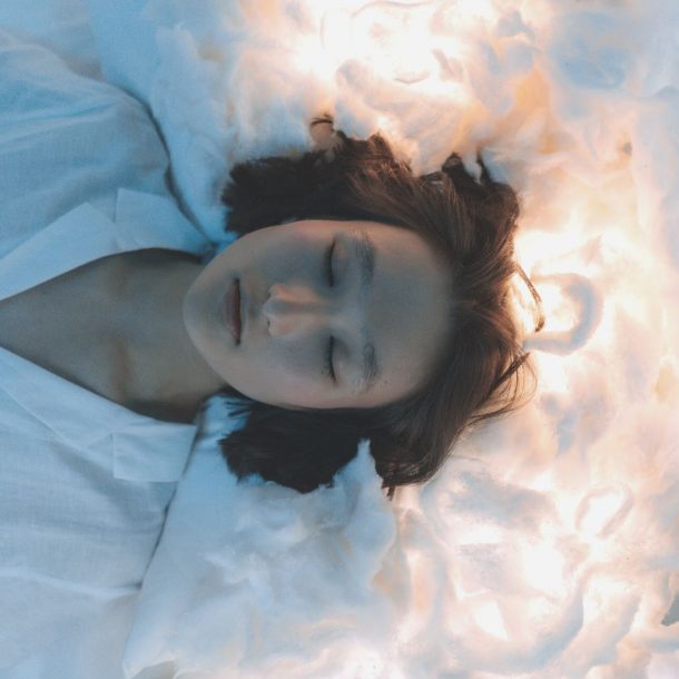 woman lying on white cotton