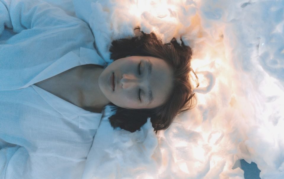 woman lying on white cotton