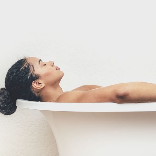 side view of young woman having a bath
