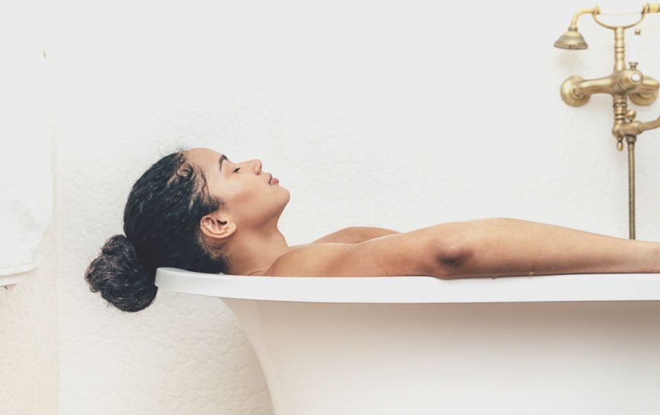 side view of young woman having a bath