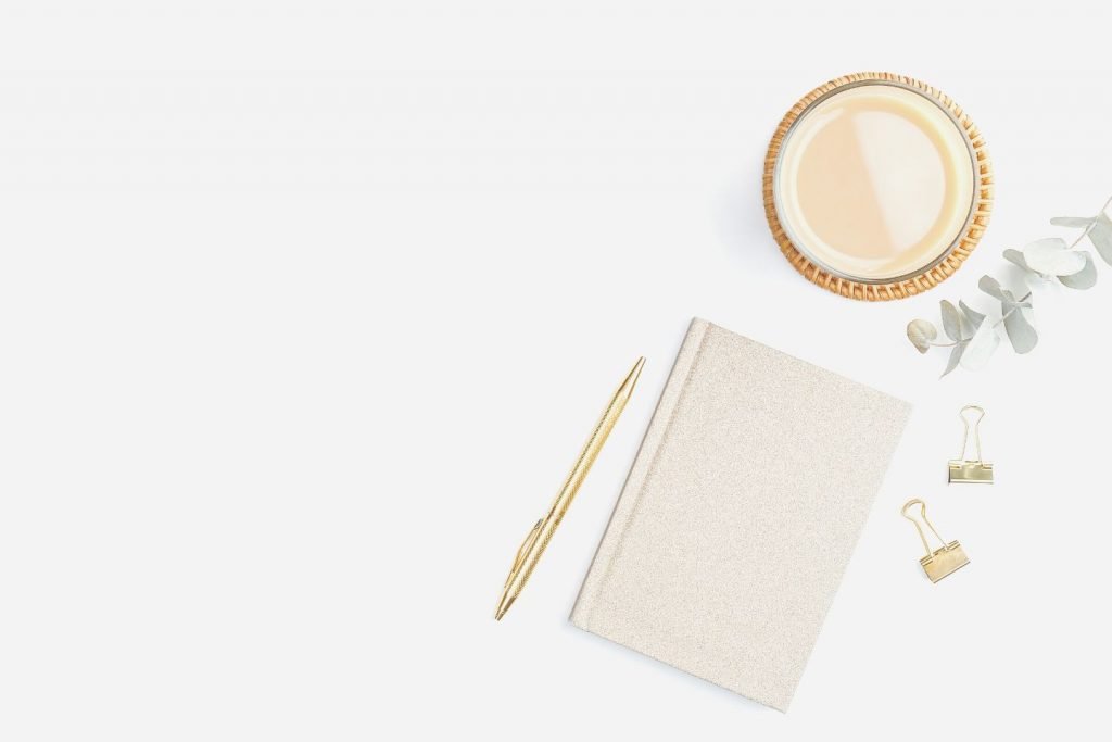 closed journal next to candle on desk