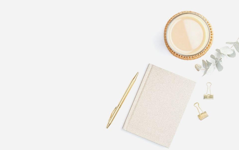 closed journal next to candle on desk