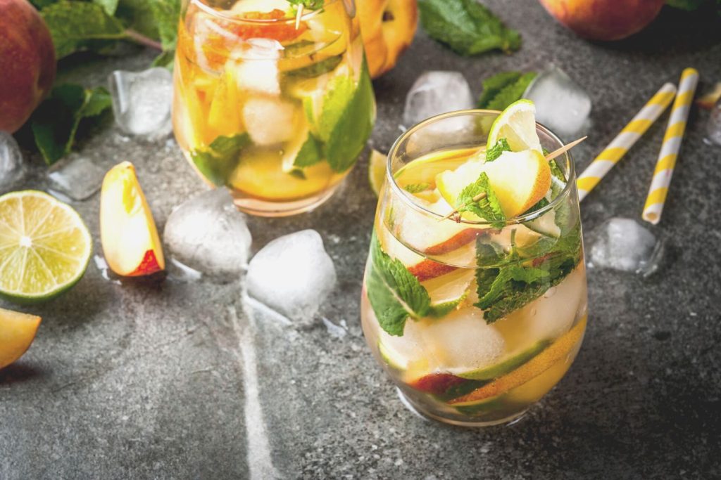 glasses of fresh peach mojito cocktail on table