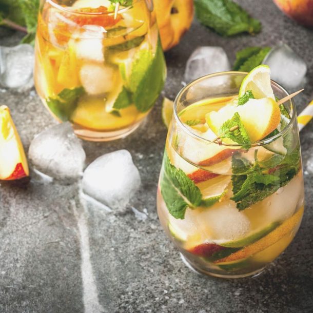 glasses of fresh peach mojito cocktail on table