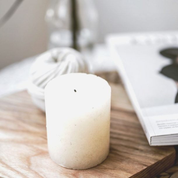 candle next to magazine on table