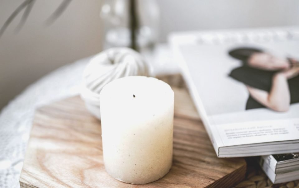 candle next to magazine on table