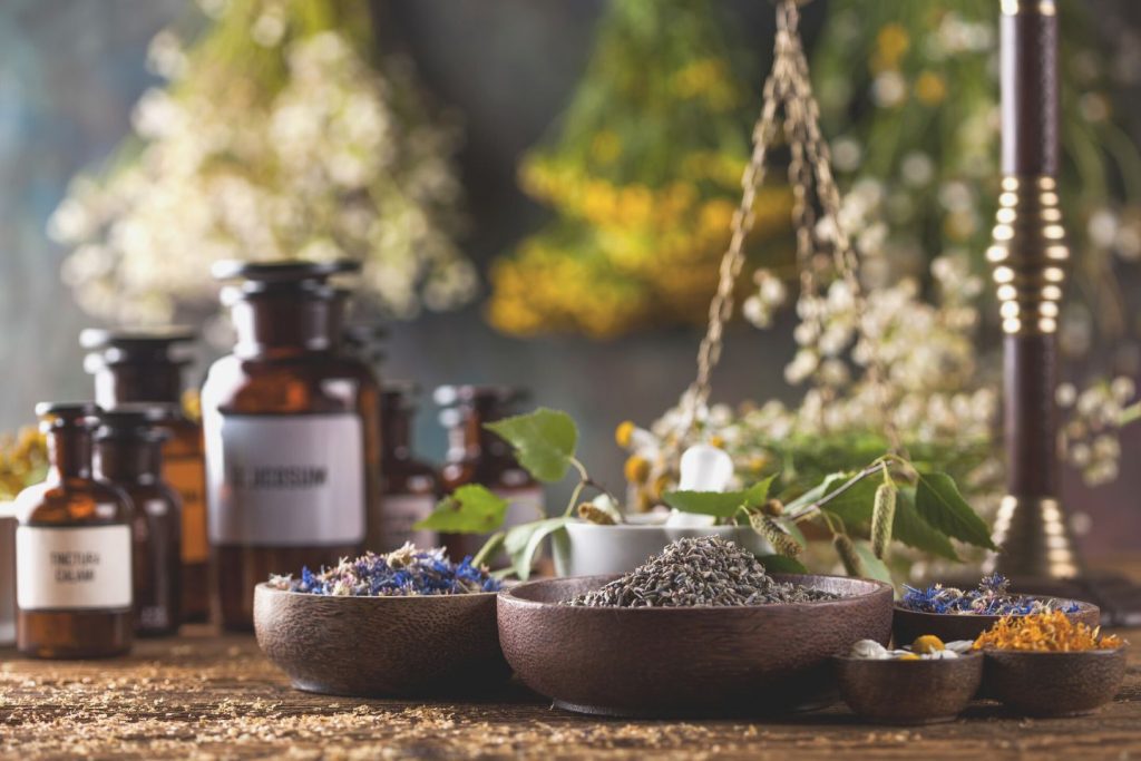 herbs medicine, natural remedy and mortar on vintage wooden desk