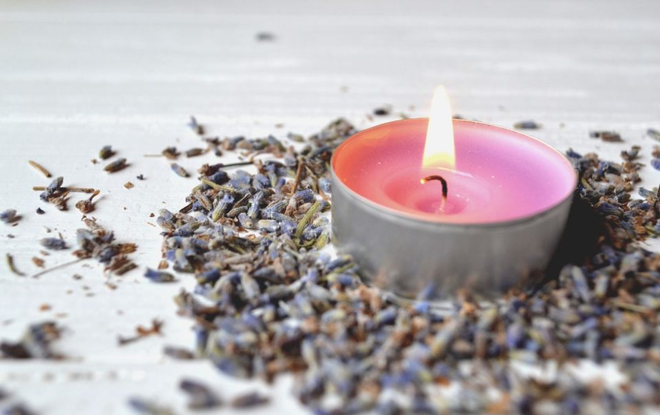 lavender flavor. violet candle in lavender flowers. lavender aromatherapy.